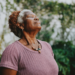 Woman over 50 standing outdoors with eyes closed in peaceful meditation
